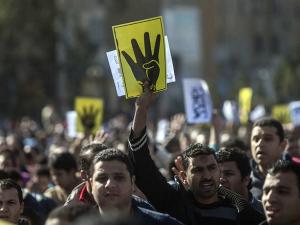 مجموعة من مؤيدي الإخوان المسلمين يحملون علامة "رابعة"