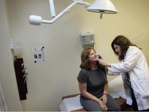 طبيبة أمراض جلدية تعاين مراجعة 