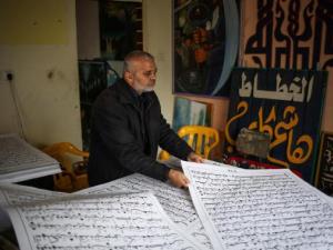 فلسطيني ينسخ المصحف بخط يده
